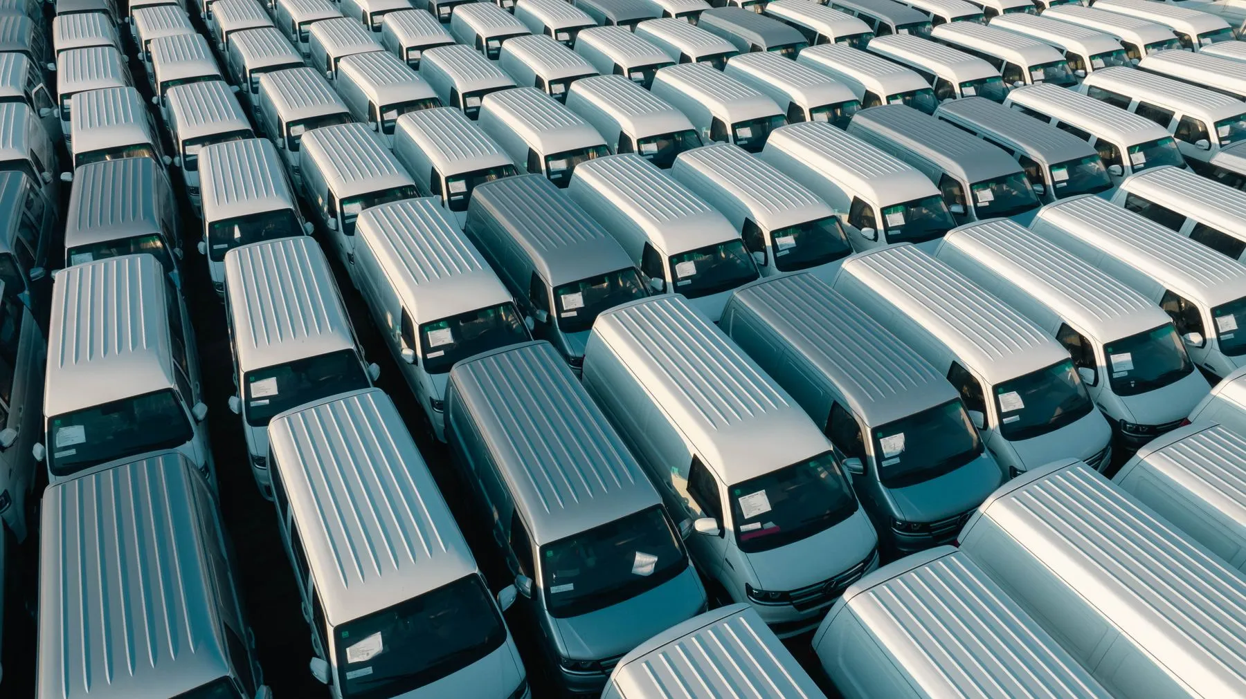 White vans parked in rows seen from above